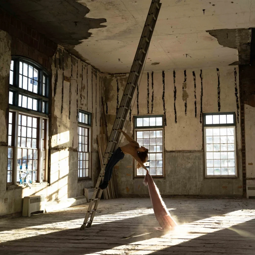 Abandoned room with peeling paint and a broken ladder.